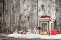 Gemütliche Weihnachtslaterne mit Lebkuchendekorationen in einer verschneiten Winterlandschaft