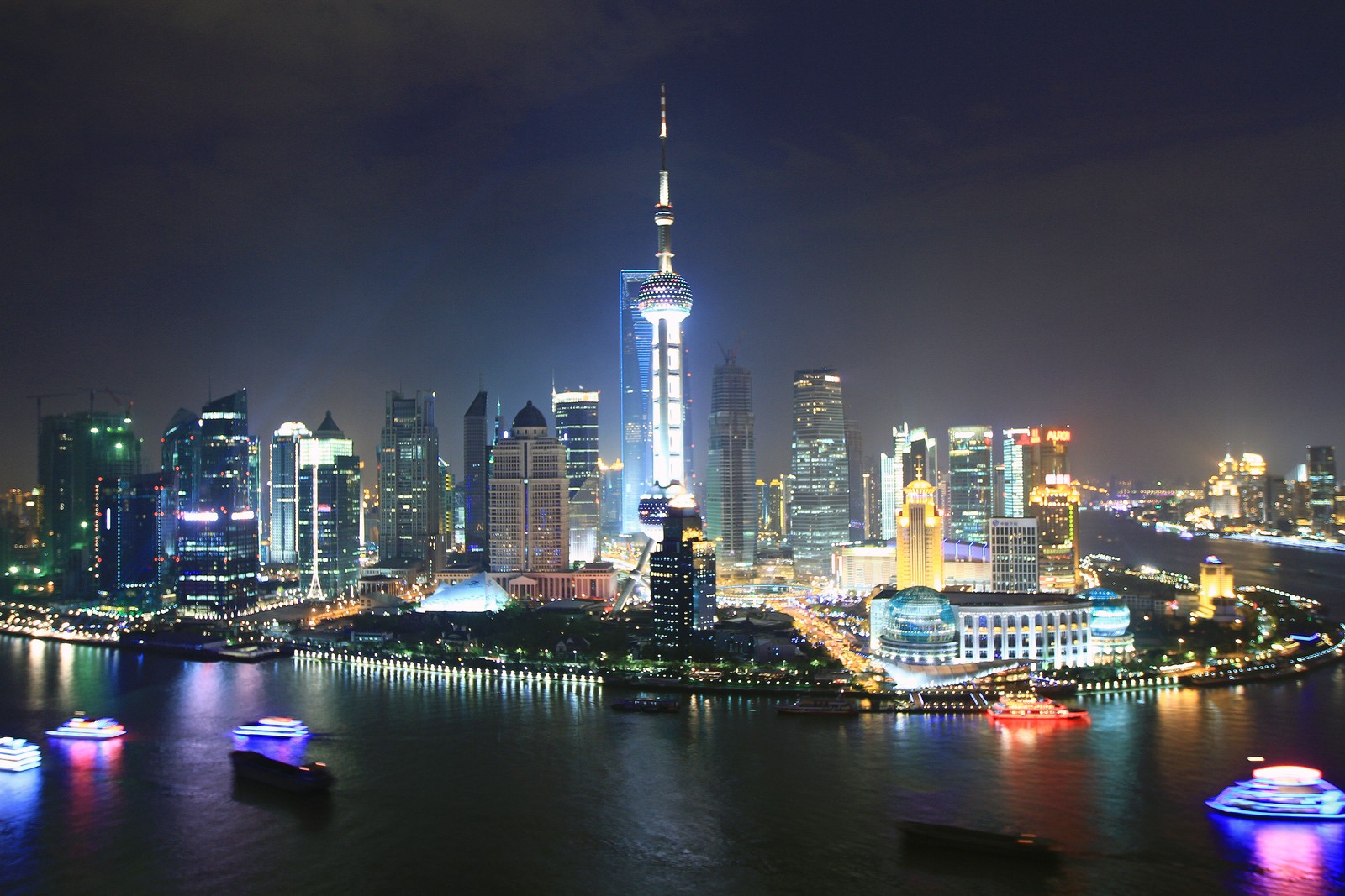 Arafelly beleuchtete stadtsilhouette bei nacht mit booten im wasser (der bund, the bund, stadt, stadtbild, skyline)