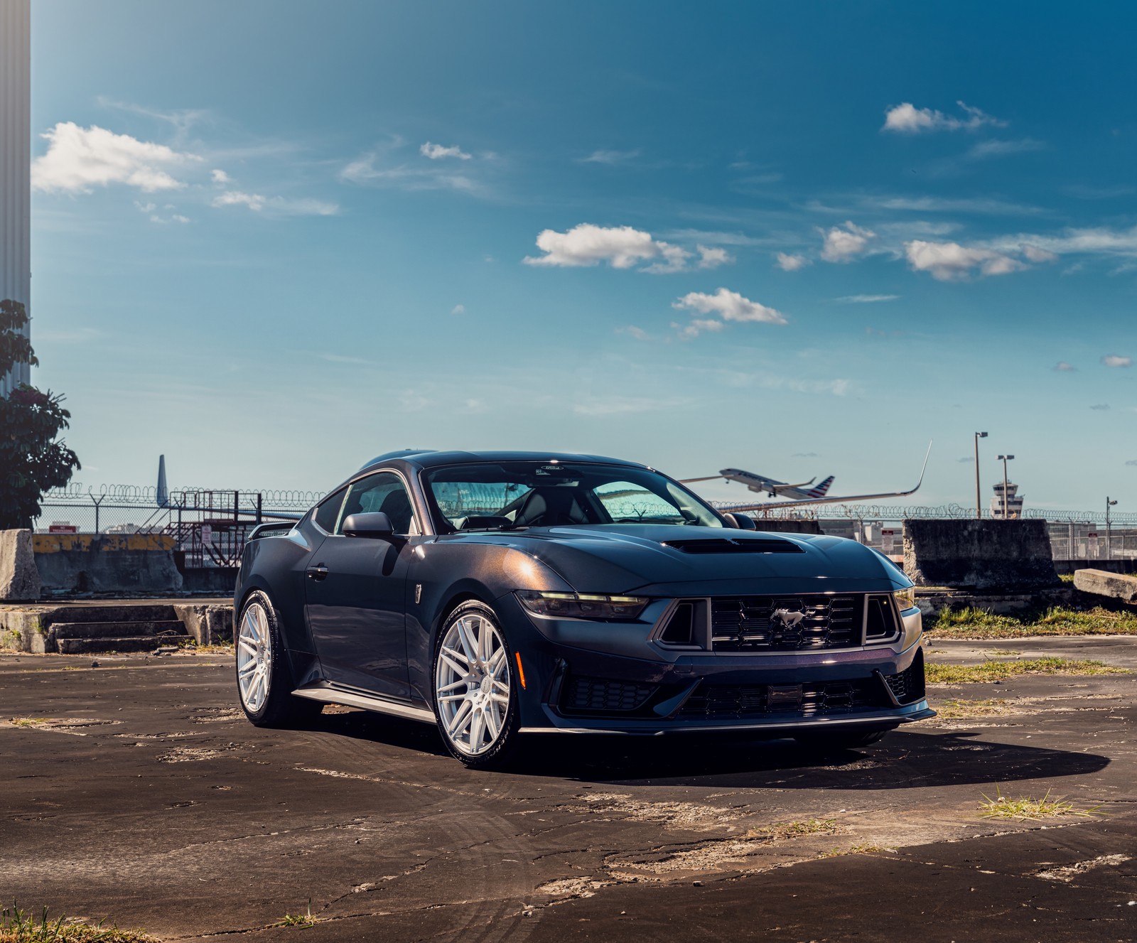 Um close de um carro estacionado em um estacionamento perto de um prédio (ford mustang dark horse, ao ar livre, 8k, 5k, carros)