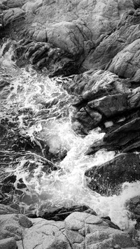 Monochrome Flow: Nature's Liquid Dance Over Bedrock