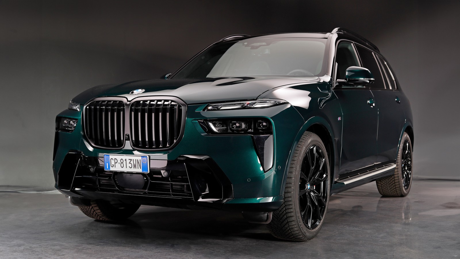 A close up of a green bmw suv parked in a garage (bmw x7 suv, 2024, 5k, cars, 4k wallpaper)