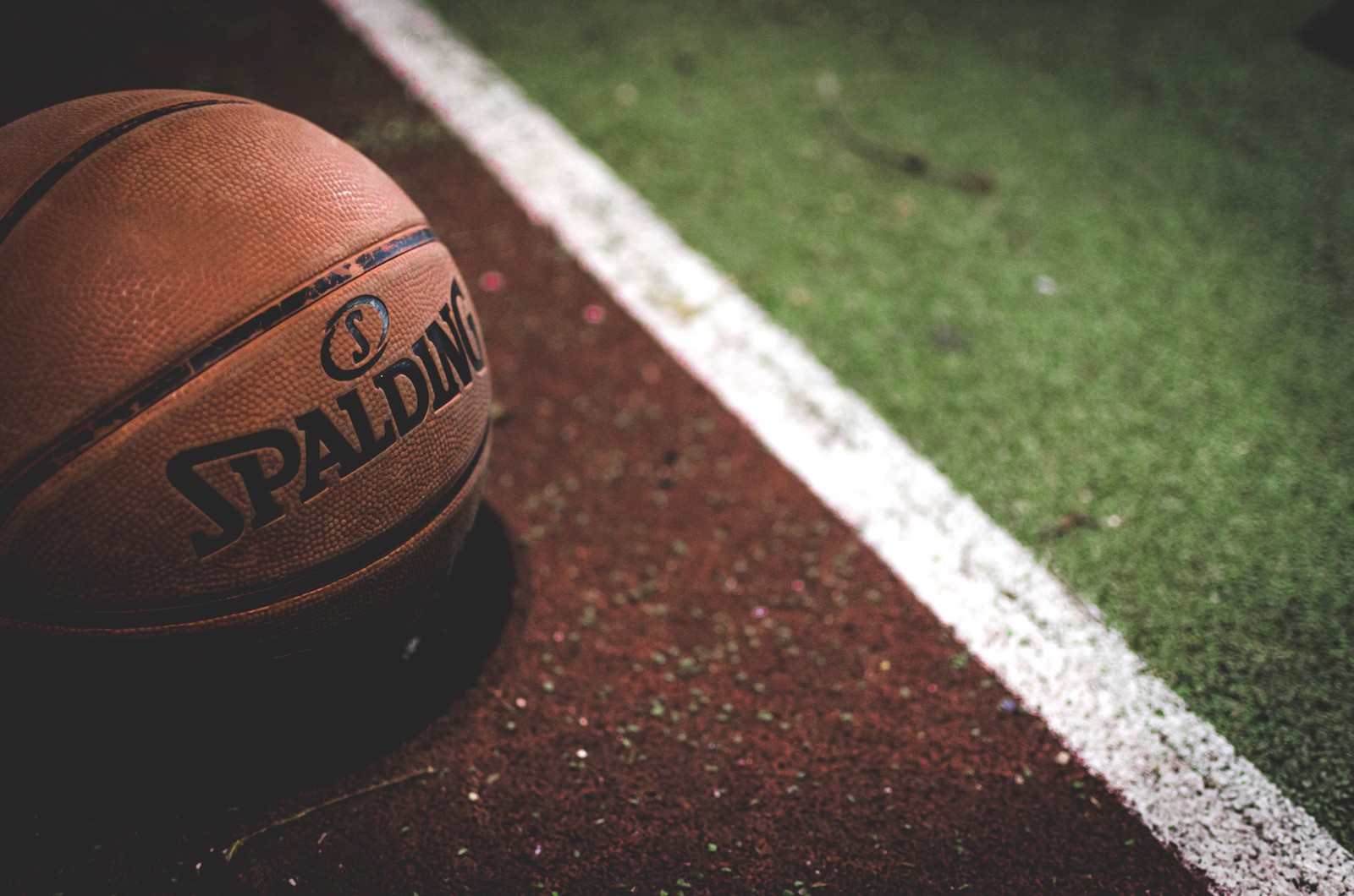 Arafed basketball ball on the ground with a white line (basketball, ball, grass, soccer ball, sport venue)