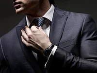 Elegant Man Adjusting His Tie in a Dark Suit