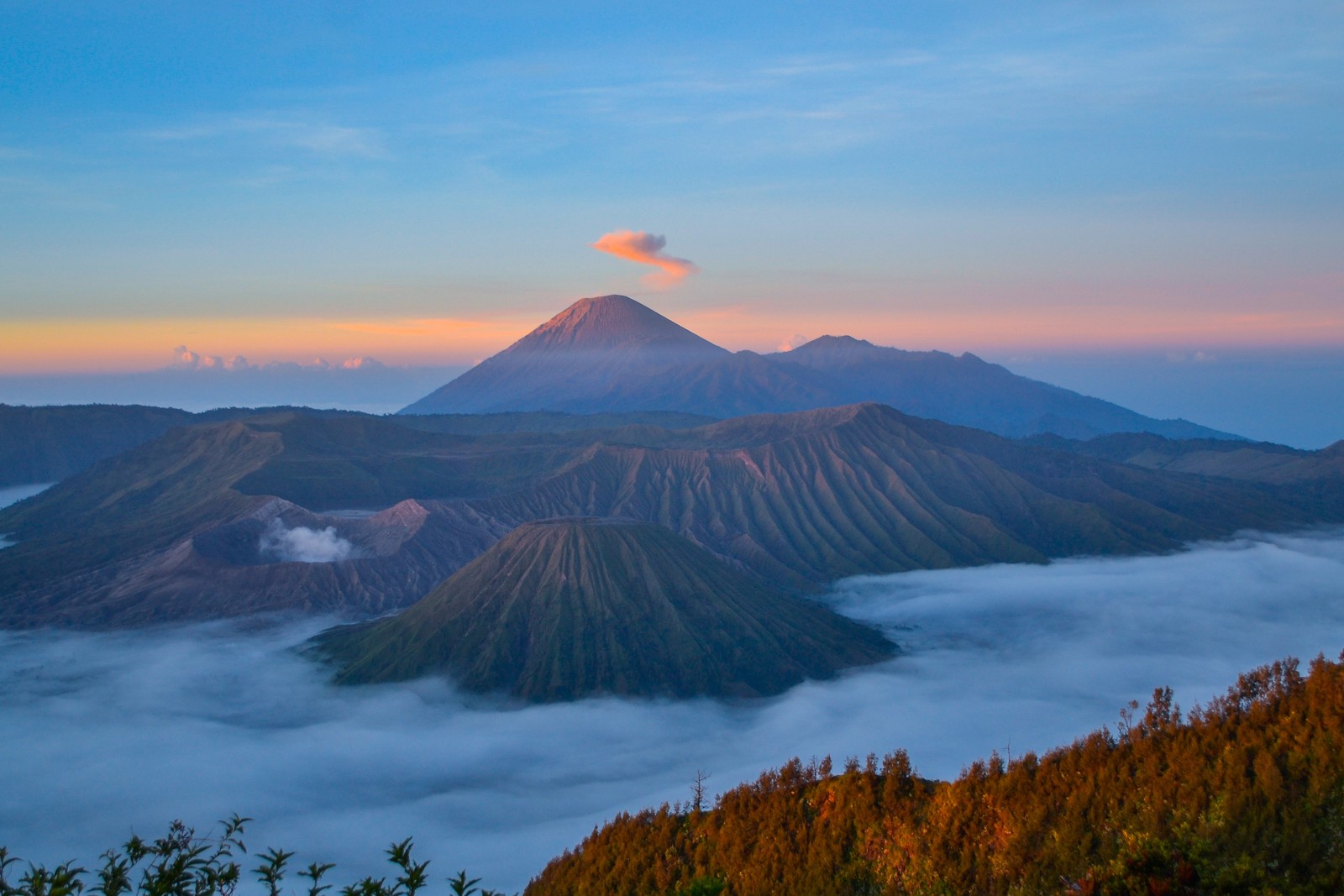 Uma vista dos vulcões e nuvens do topo de uma montanha (montanha bromo, mount bromo, vulcão, montanha, estratovulcão)