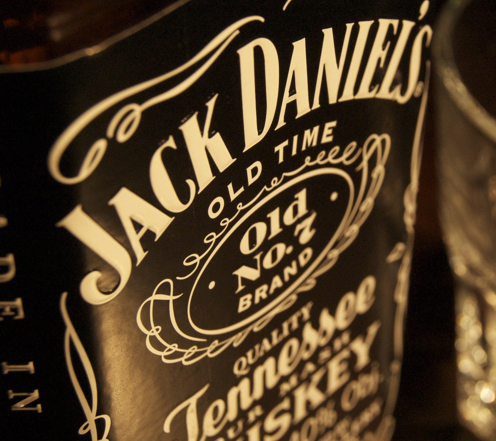 Es gibt eine flasche jack daniels whiskey neben einem glas (alkohol, daniels, jack, logo)