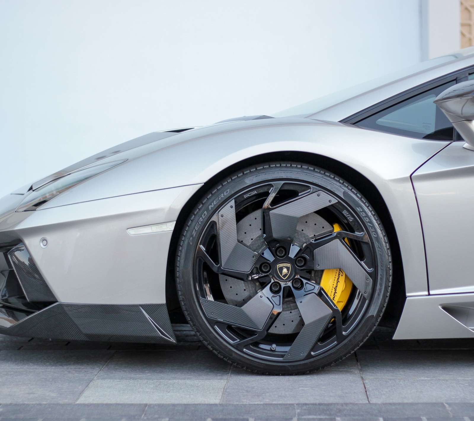 A close up of a silver sports car parked on a street (automobile, car)