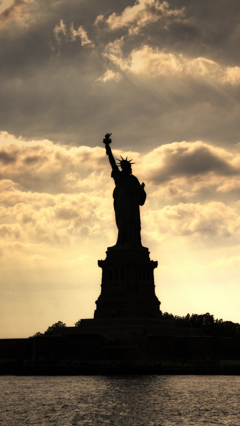 Estátua da liberdade em silhueta contra um céu nublado (arquitetura, edifícios, cidade, paisagens)