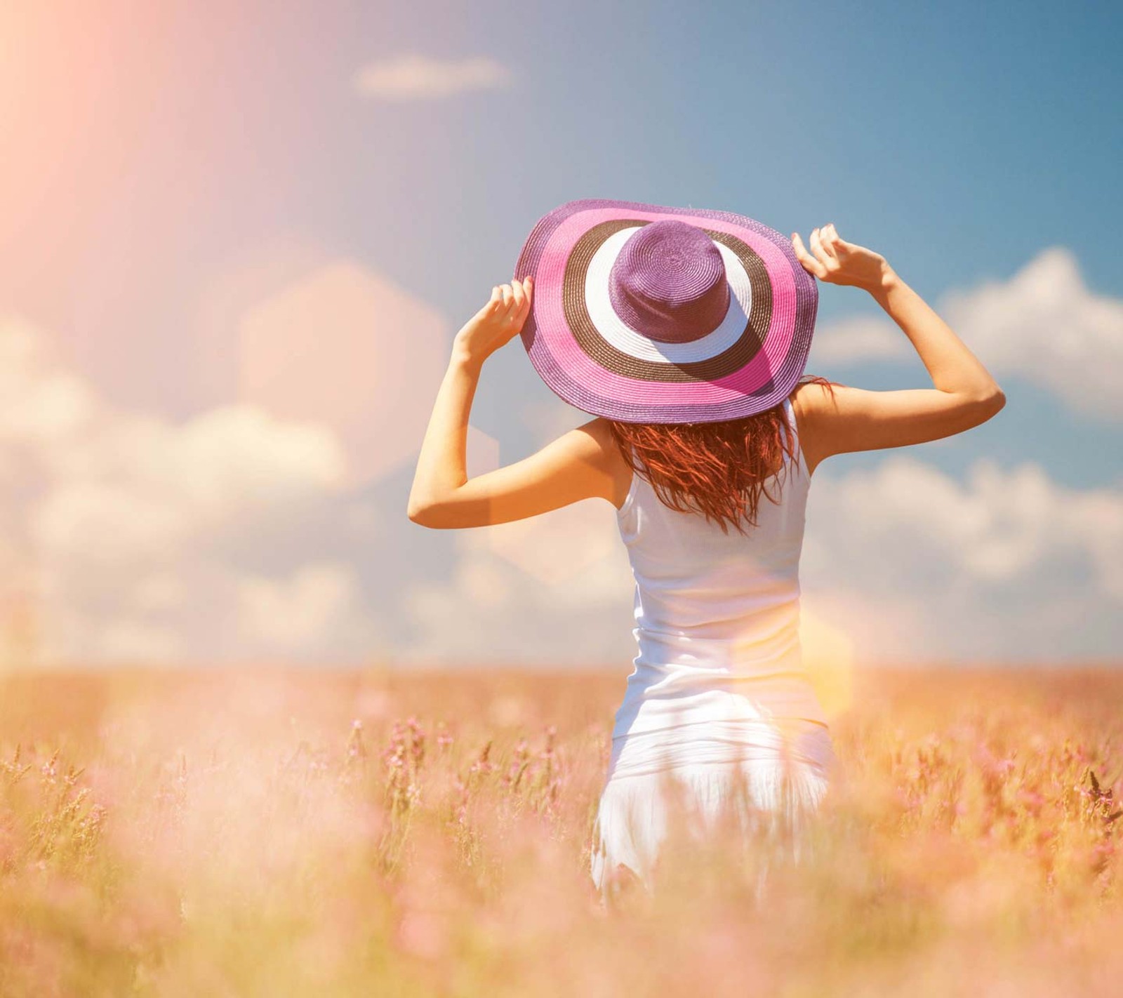 Un graffiti d'une femme dans un champ de fleurs avec un chapeau (liberté, fille, dame, vie, lumière)