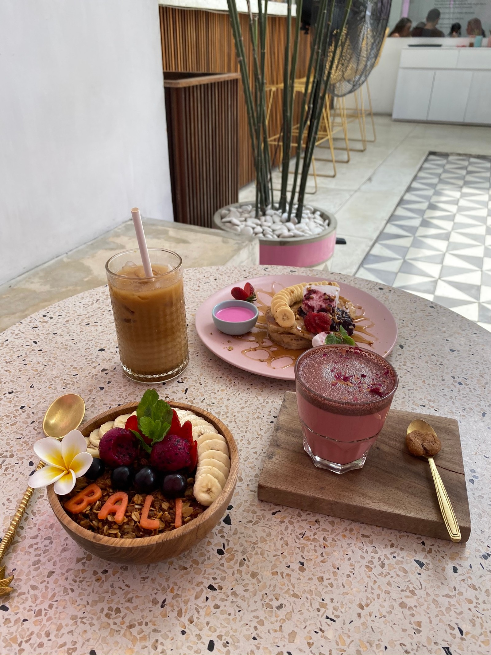 Uma tigela de frutas e um copo de suco sobre uma mesa (bali, brunch, café da manhã, sobremesa congelada, comida)