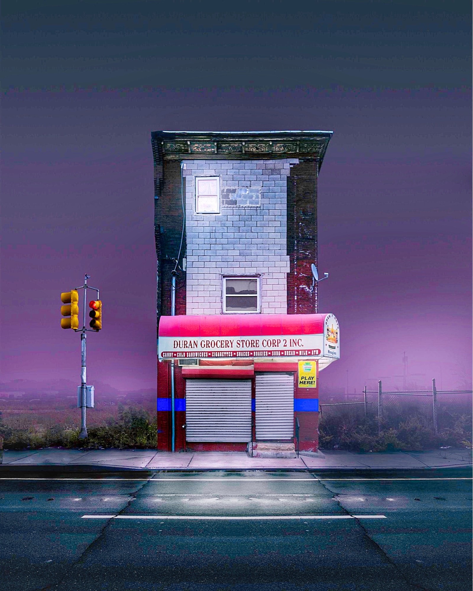 There is a building that has a store front on the corner (landmark, purple, road surface, asphalt, automotive lighting)