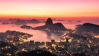 Crépuscule époustouflant sur la plage de Copacabana : un mélange tranquille de mer, de montagnes et de lumières de la ville