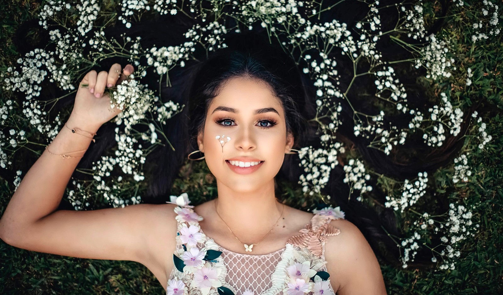 Une femme allongée sur le sol avec des fleurs dans les cheveux (fille souriante, belle fille, fleurs blanches, gens, fond décran 4k)