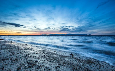 Gelassener Sonnenuntergang über den Ozeanwellen und dem Dämmerungshimmel