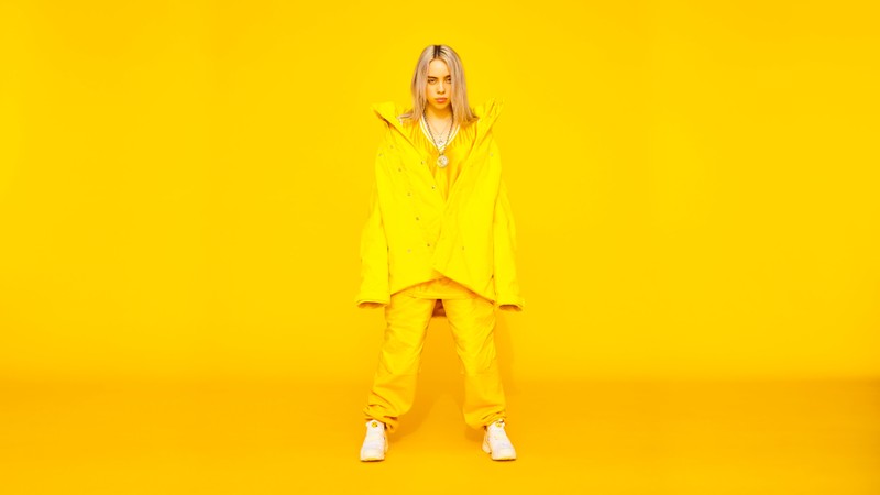 Женщина в желтом дождевике стоит на желтом фоне (billie eilish, певец, знаменитость, девочки)