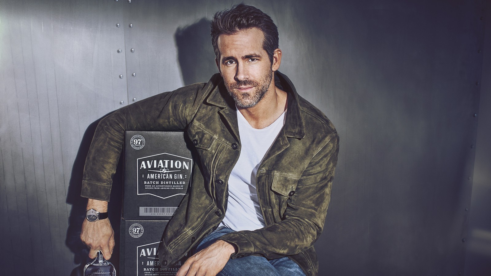 Homem arafed sentado em um banco segurando uma garrafa de álcool (ryan reynolds, ator, celebridade, aviation gin)