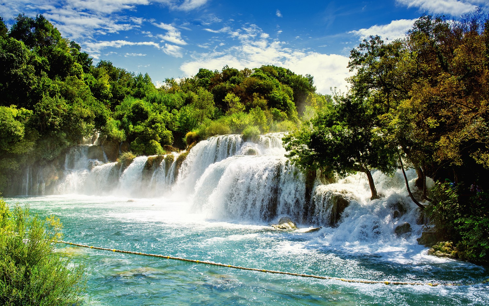 A waterfall in the middle of a forest with trees and water (krka national park, waterfall, national park, park, body of water)