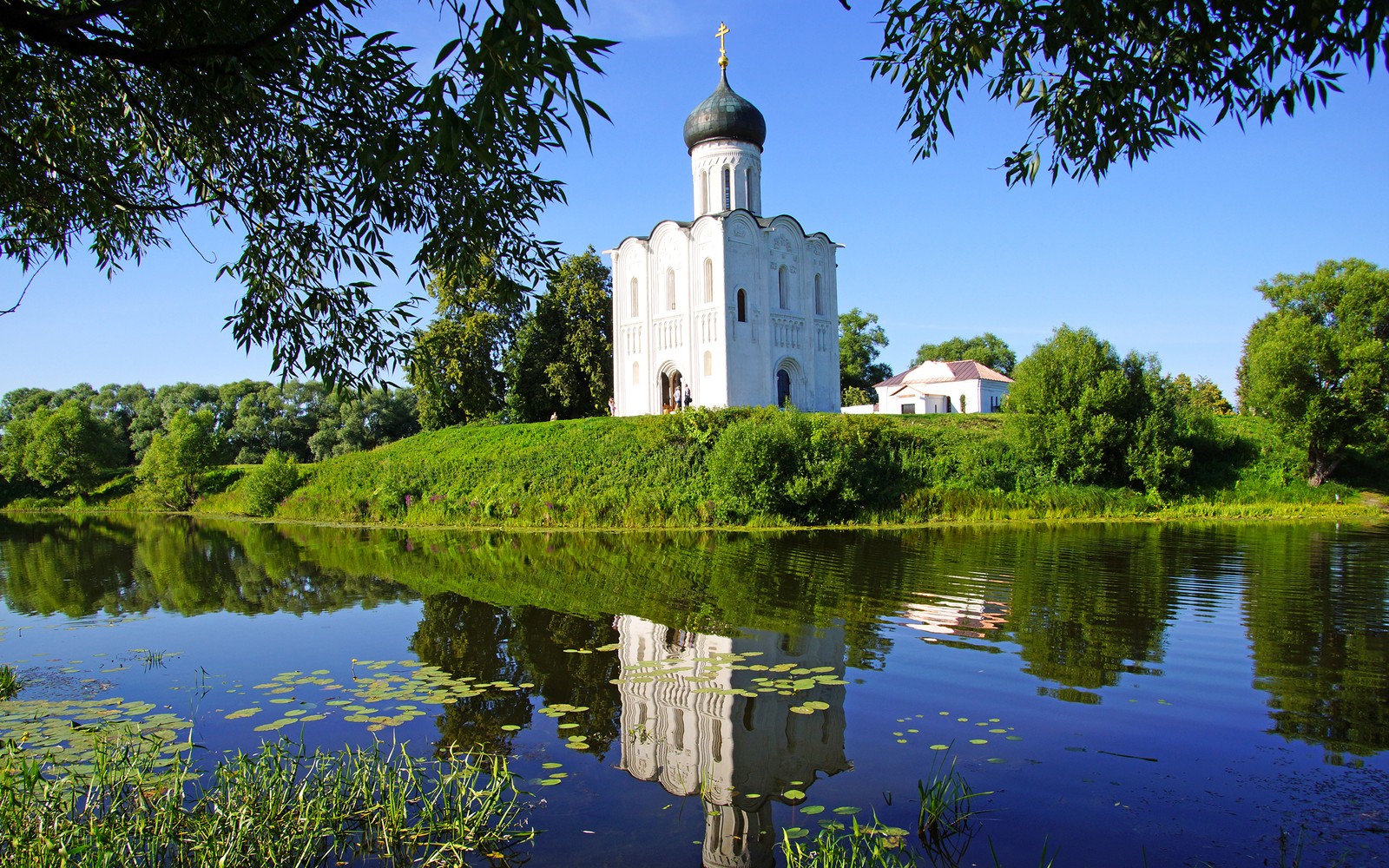 Arafed church on a hill overlooking a lake and a forest (nature, city, reflection, water, landmark)