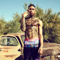 NLE Choppa posando con tatuajes en un entorno abandonado