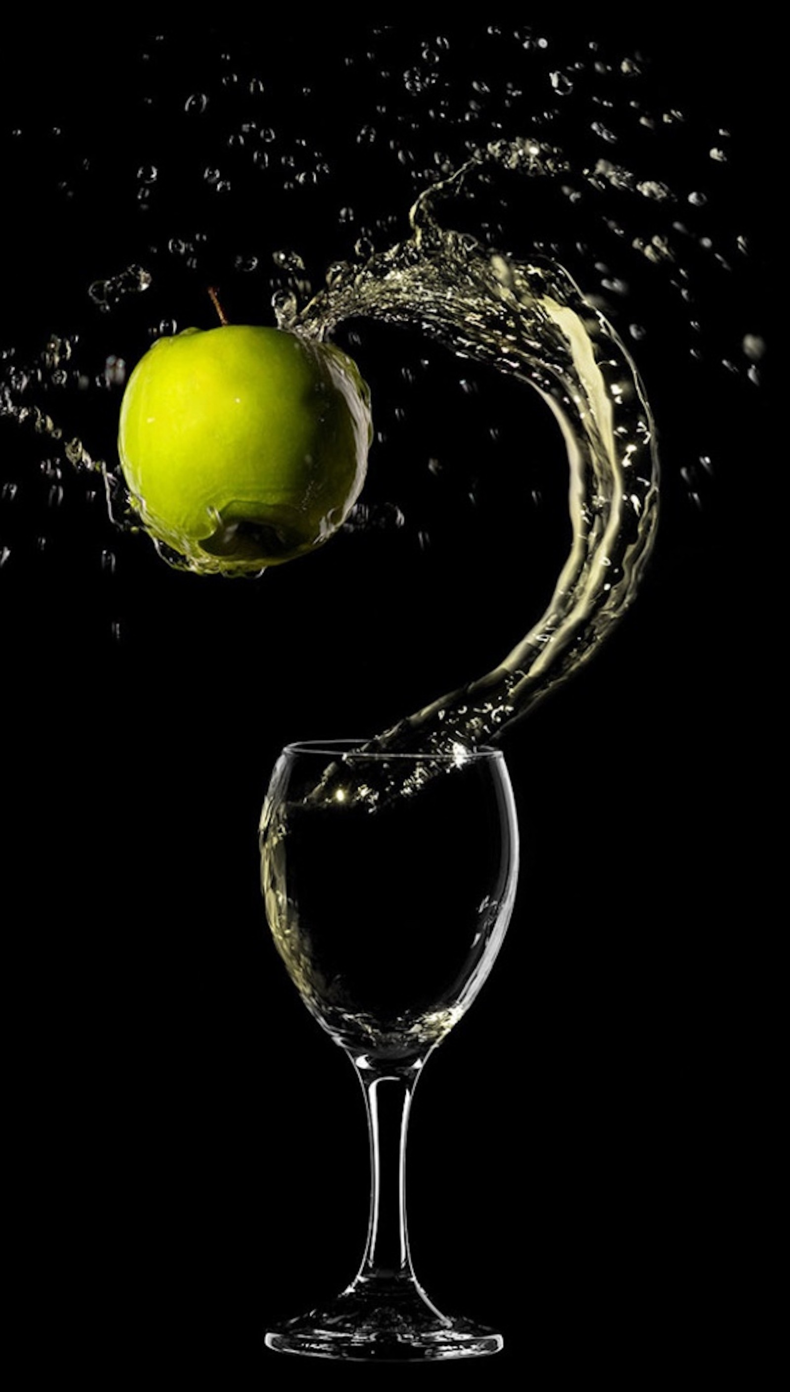 Arafed apple falling into a glass of water with a splash (mnb, vgc)