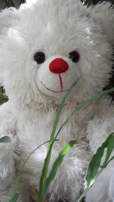 Mignon ours en peluche blanc entouré de nature verte