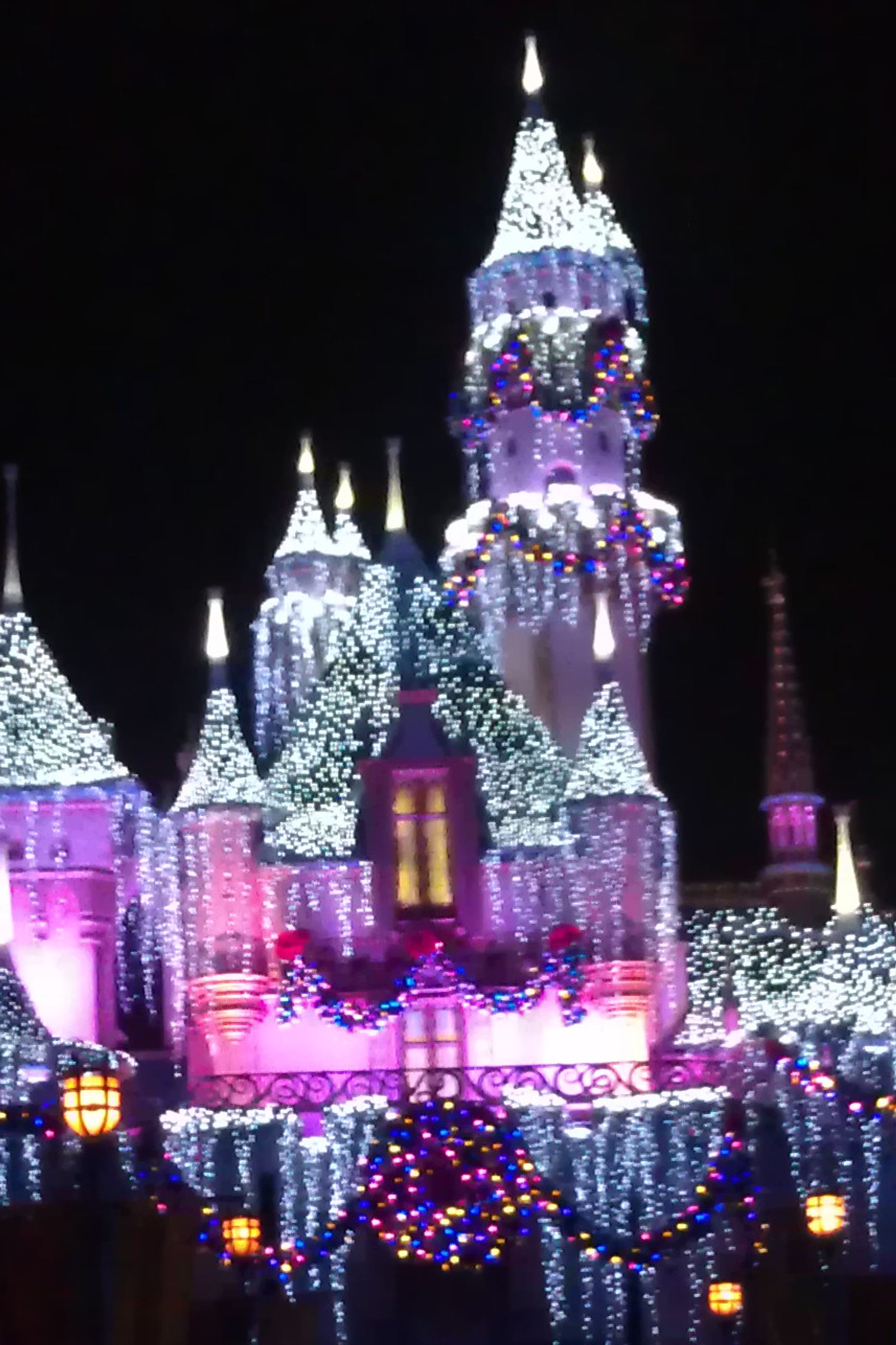 Château arafé avec des lumières et des décorations de noël dans l'obscurité (noël, disneyland, lumières)