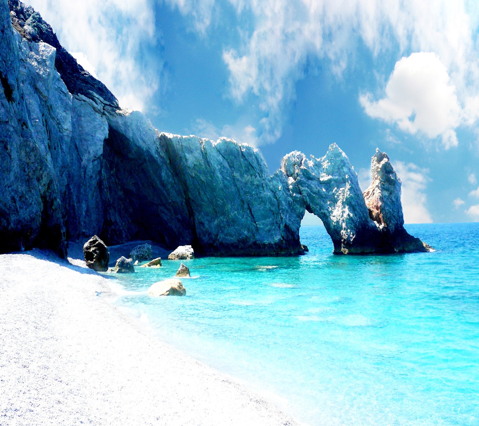 Hay una gran formación rocosa en la playa con un océano azul (playa, paisaje)