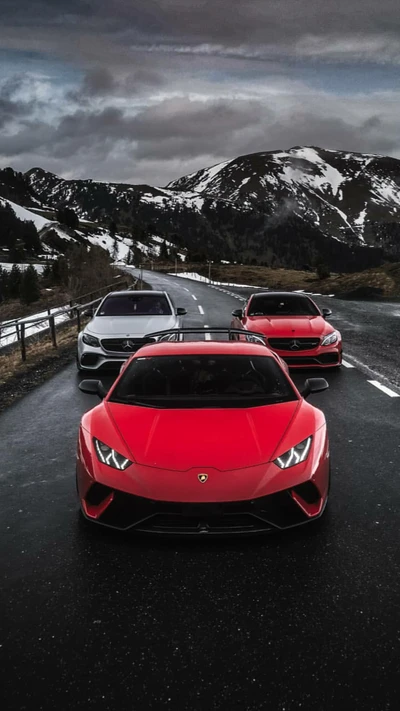 Lamborghini Huracán vermelho e supercarros Mercedes em uma estrada de montanha