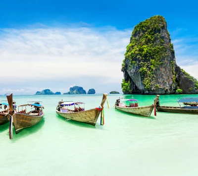 Tropical Paradise: Boats Anchored by Scenic Rocks and Lush Trees