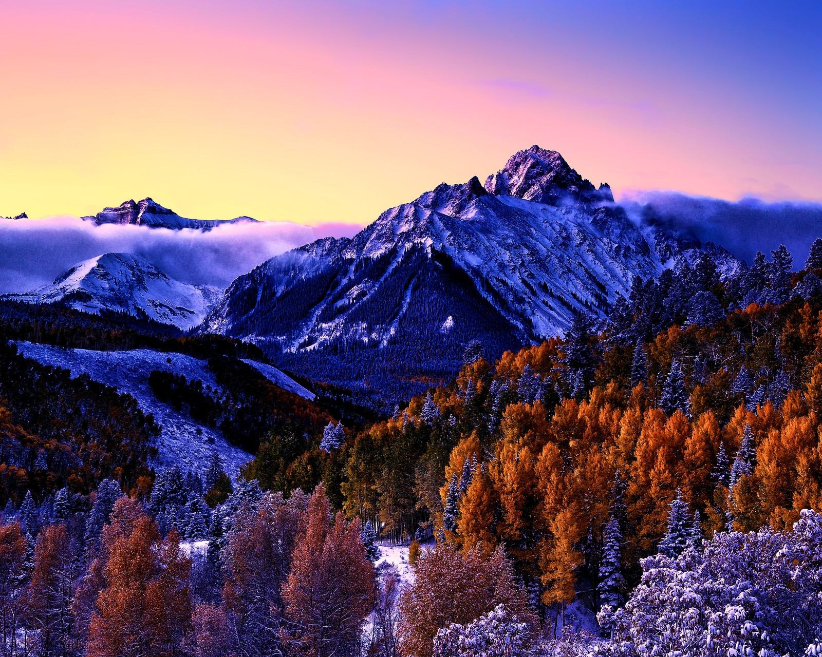 Des montagnes couvertes de neige et des arbres avec un coucher de soleil en arrière-plan (montagne sneffels, colorado, couvert de neige, arbres de peuplier, brume)