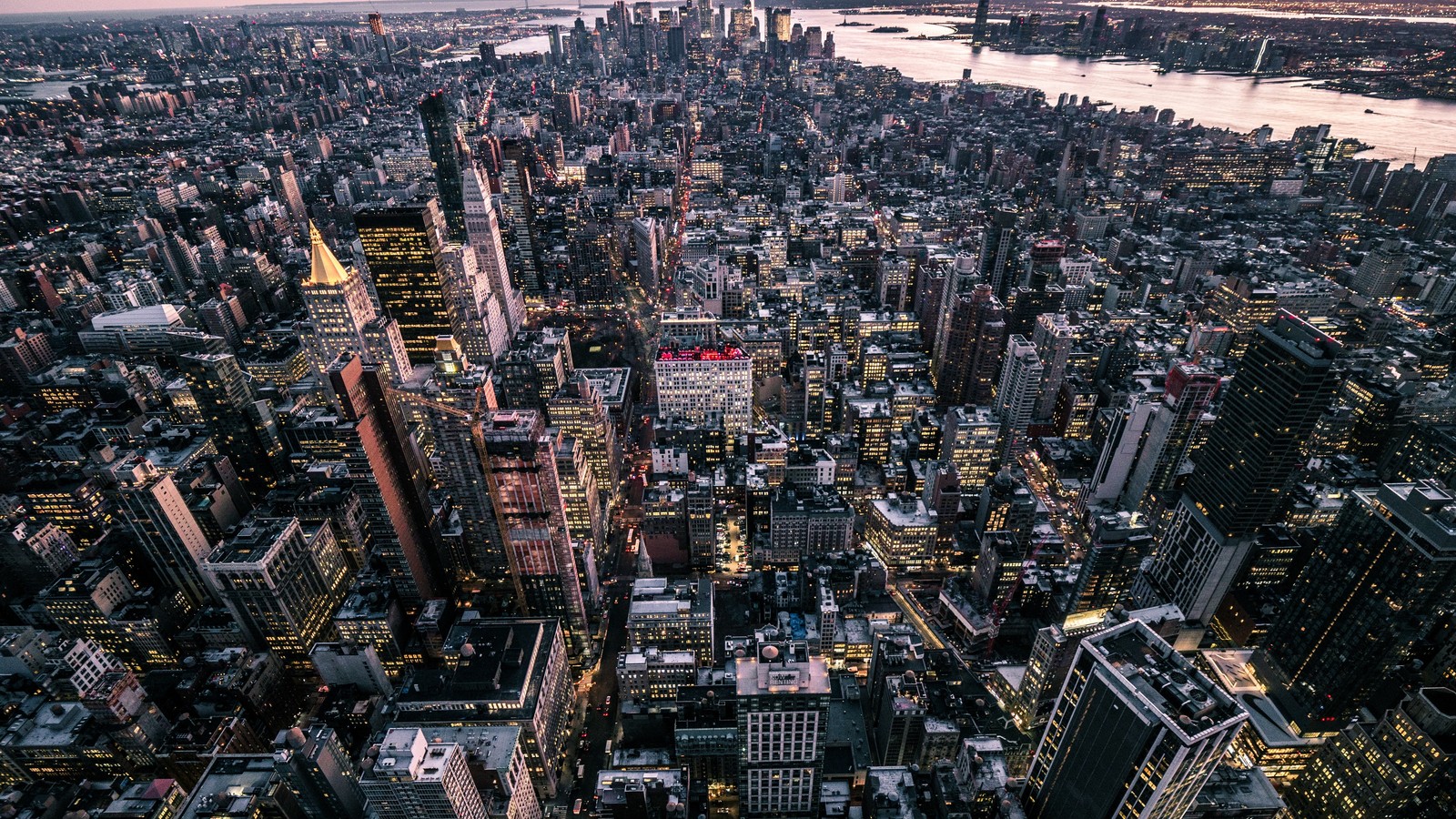 Vista de una ciudad al anochecer con un río de fondo. (nueva york, new york city, ciudad, paisaje urbano, área urbana)