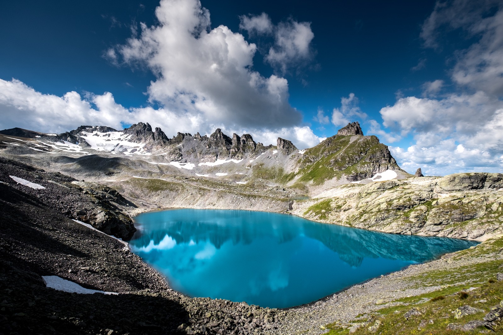 Вид на голубое озеро в горах со снегом на земле (pizol five lake hike, альпы, швейцария, пешеходная тропа, живописный)