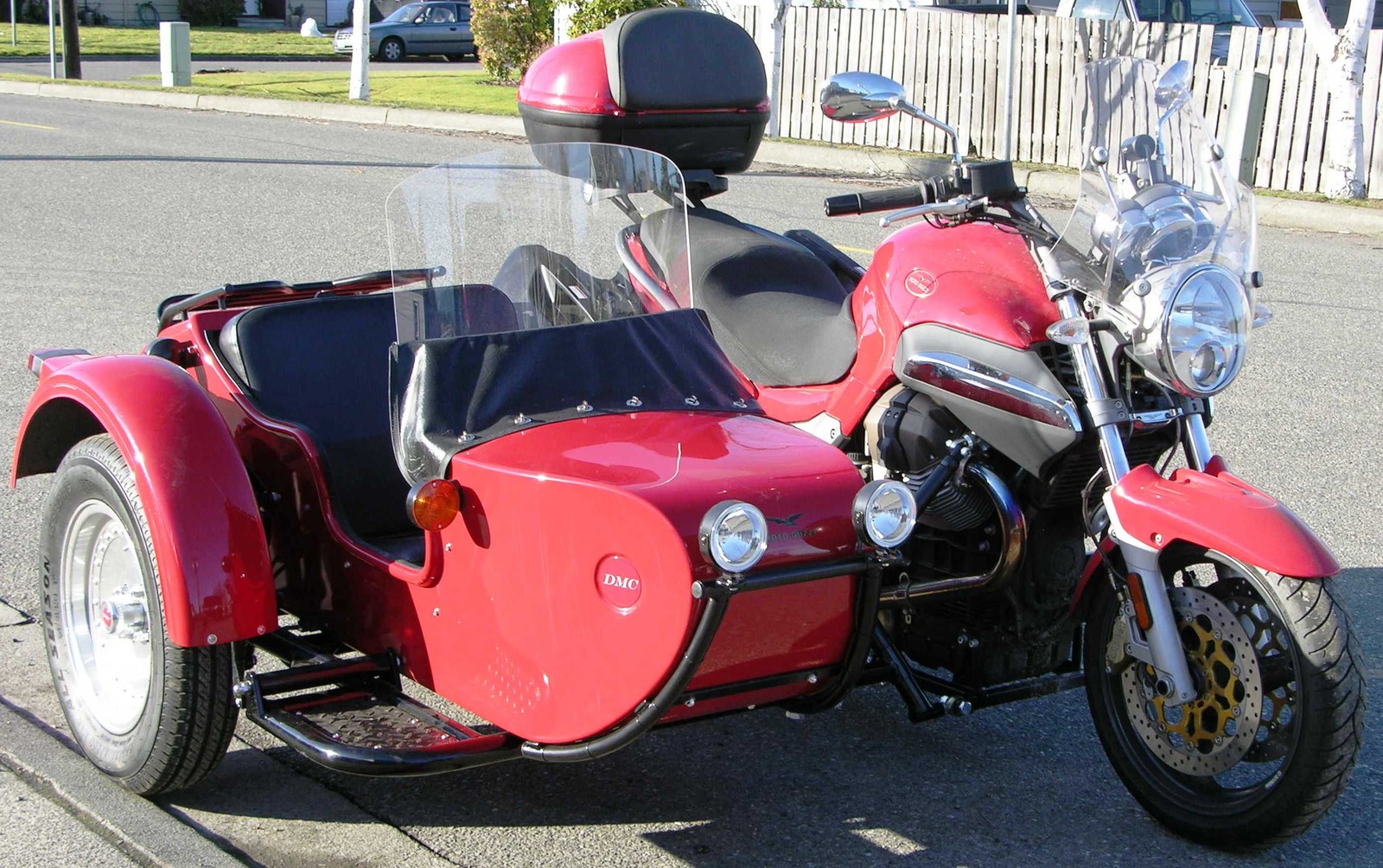 Motorcycle with side car parked on the side of the road (car, motorcycle, motorcyclist, baby carriage, motorized tricycle)