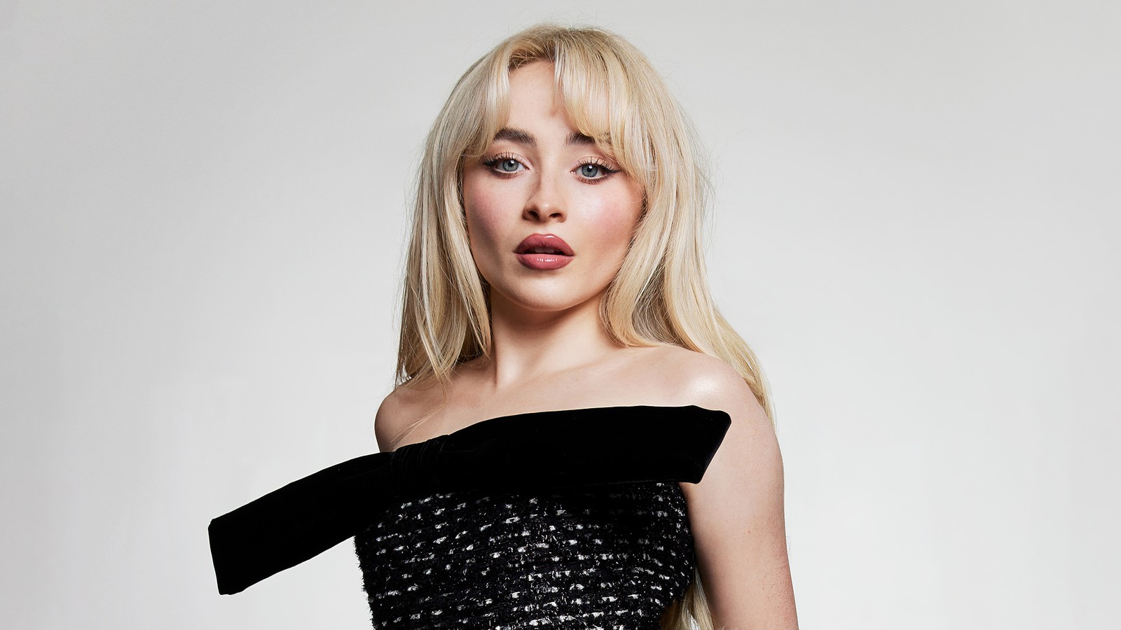 Блондинка в черном платье позирует для снимка с луком (сабрина карпентер, sabrina carpenter, белый фон, американский певец, 5k)