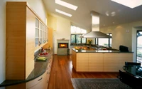 Elegant modern kitchen featuring sleek cabinetry, a spacious countertop, and warm hardwood flooring, accentuated by natural light from skylights and a stylish pendant light.