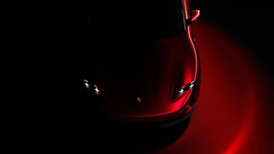 Porsche Taycan rojo iluminado contra un fondo oscuro