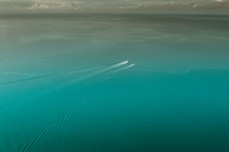 Арабская лодка посреди океана на фоне неба (синий, море, вода, аква, бирюза)