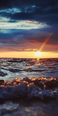 Pôr do sol sobre um horizonte alemão sereno com nuvens atmosféricas e ondas suaves do oceano