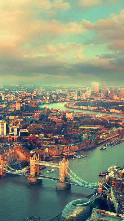 Luftaufnahme der ikonischen Tower Bridge in London, die die Themse überspannt, umgeben von städtischer Landschaft und üppigem Grün.