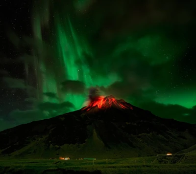 Erupción de lava bajo las auroras boreales en la cima de la montaña