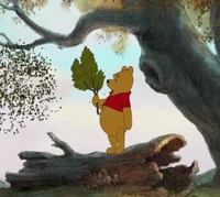 Winnie l'Ourson tenant une branche sous un arbre