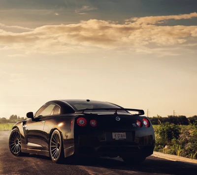 Carro esportivo preto elegante contra um céu de pôr do sol