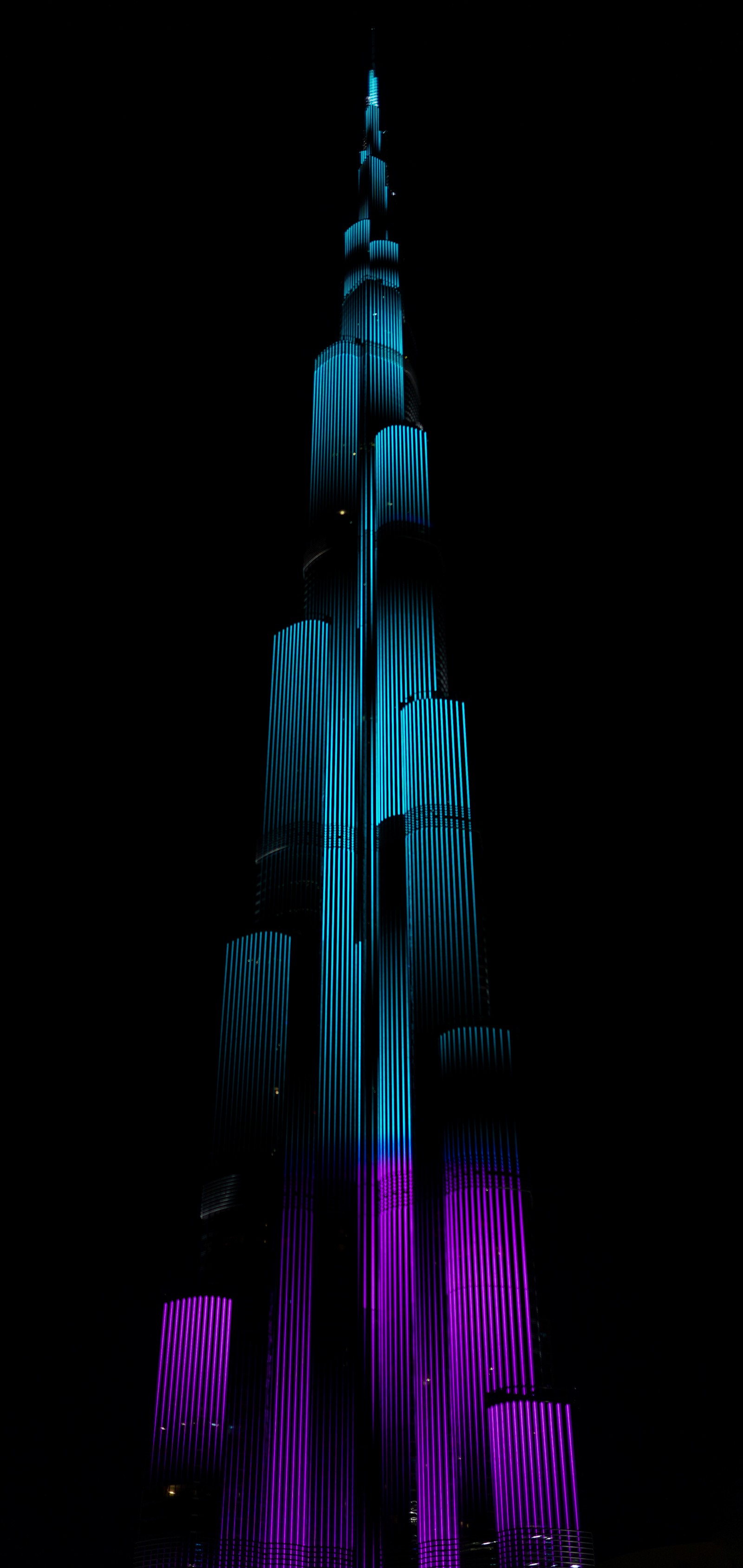 Arafed image of a tall building lit up in purple and blue (burj khalifa, the dubai fountain, building, skyscraper, tower)