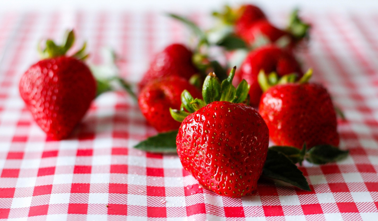 Un primer plano de un montón de fresas sobre una mesa (fresa, fruta, baya, alimentos naturales, comida)