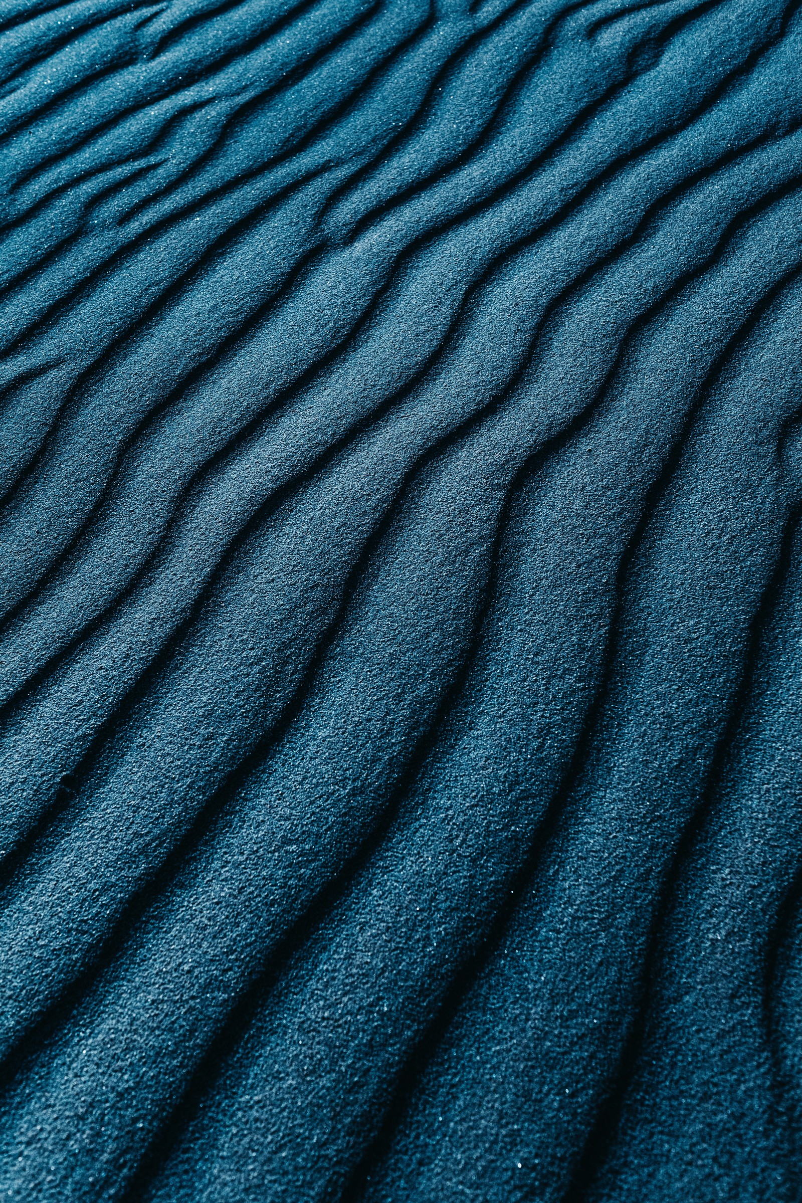 Photo arabe d'une dune de sable bleue avec un seul objet blanc (sable, motif, texture, turquoise, bleu cobalt)