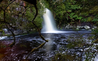 Chute d'eau majestueuse se déversant à travers une luxuriante forêt tropicale