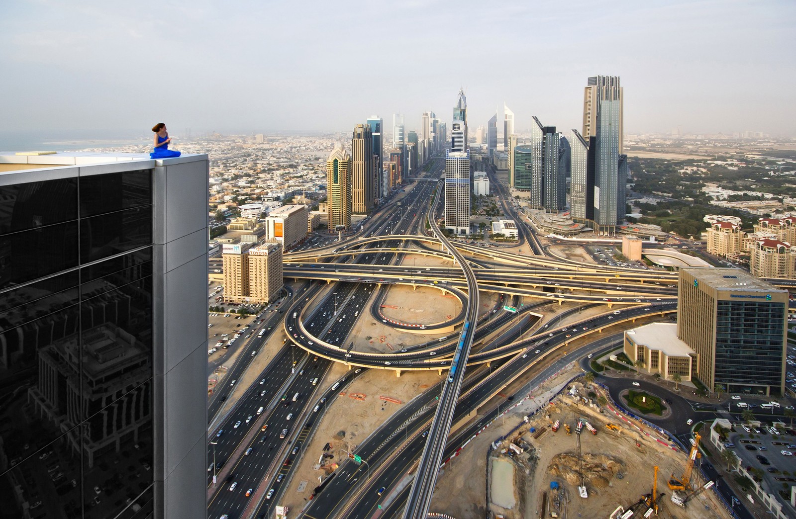 Girafes sur le toit d'un bâtiment surplombant une ville avec une autoroute (burj khalifa, gratte ciel, selfie, bâtiment, paysage urbain)