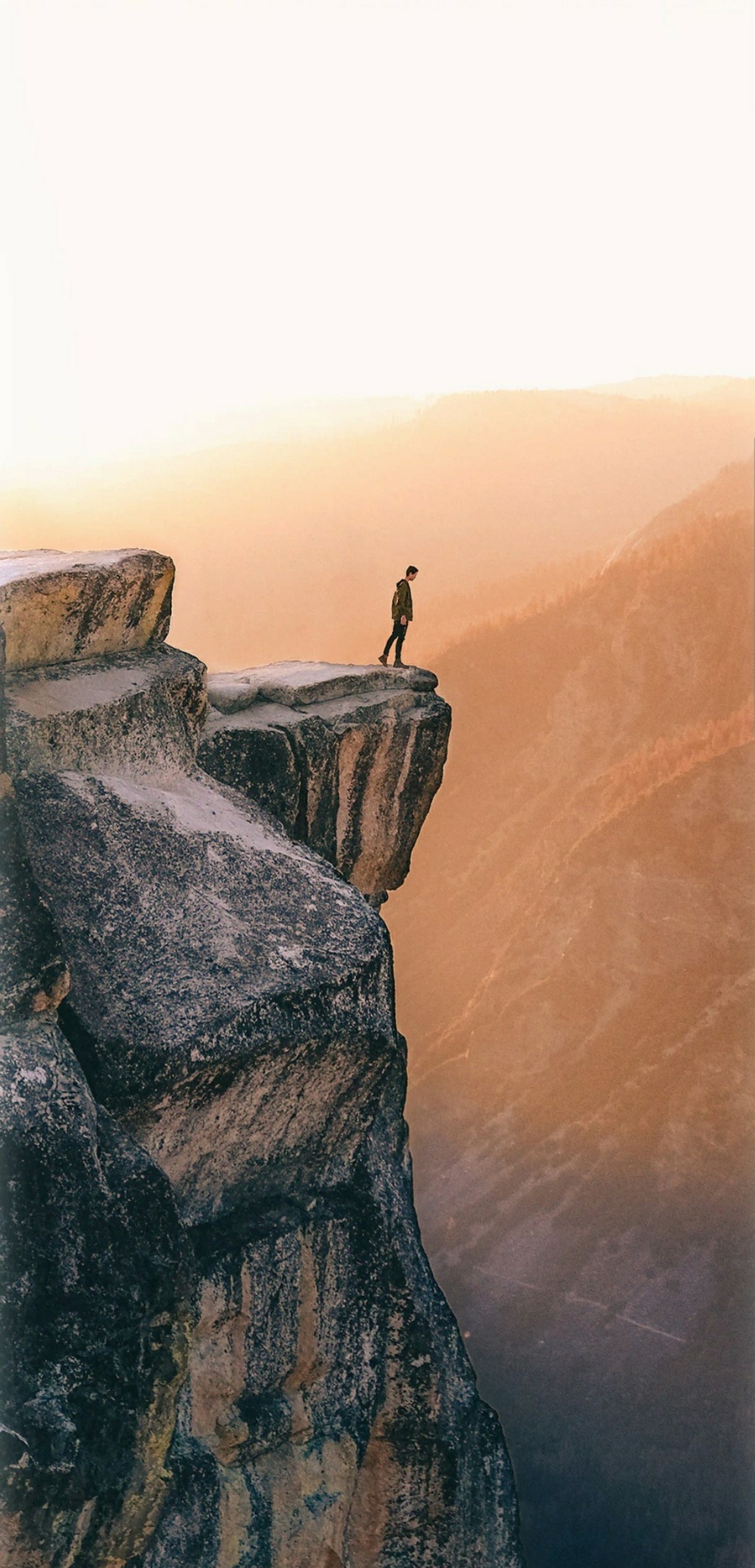 There is a man standing on a cliff with a view of the valley (mountain, natures, sea, view)