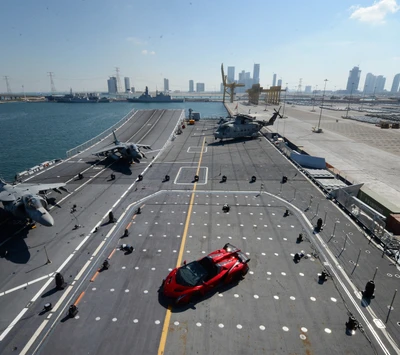 Coche deportivo rojo en un portaaviones con vista al mar