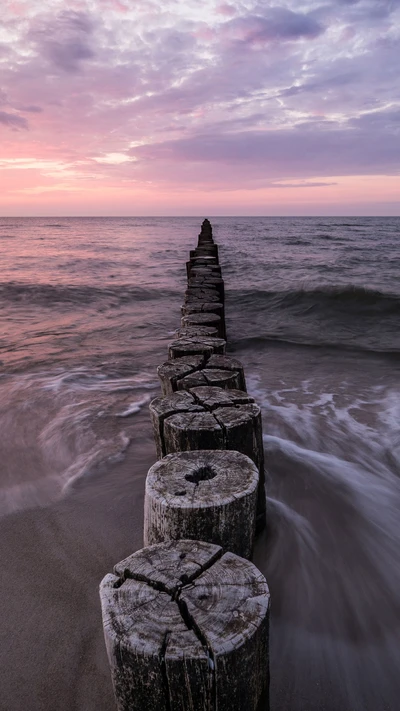 Sereno atardecer sobre el mar con espigones de madera