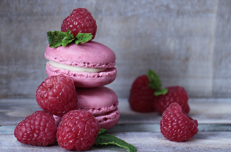 Близкий план стопки малиновых макаронов с несколькими малинами (макарон, macaron, десерт, малина, кондитерское изделие)